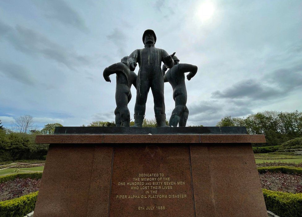 A statue of three oil rig workmen. Written on the base: "DEDICATED TO THE MEMORY OF THE ONE HUNDRED AND SIXTY SEVEN MEN WHO LOST THEIR LIVES"